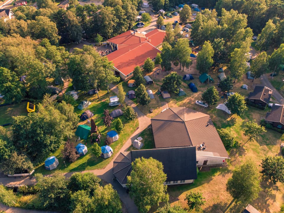 Ett drönarfoto över Gullbrannagården. Byggnader syns uppifrån i sommarsolen